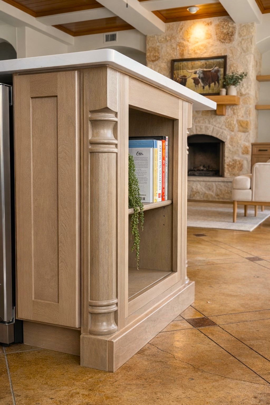Custom kitchen island with decorative columns and open shelving in warm oak finish by QW Kitchen & Bath Austin