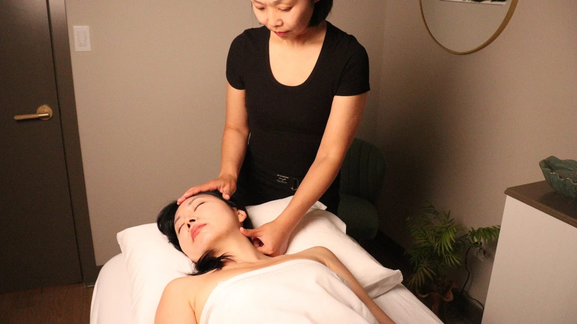 Practitioner massaging a patient's neck.