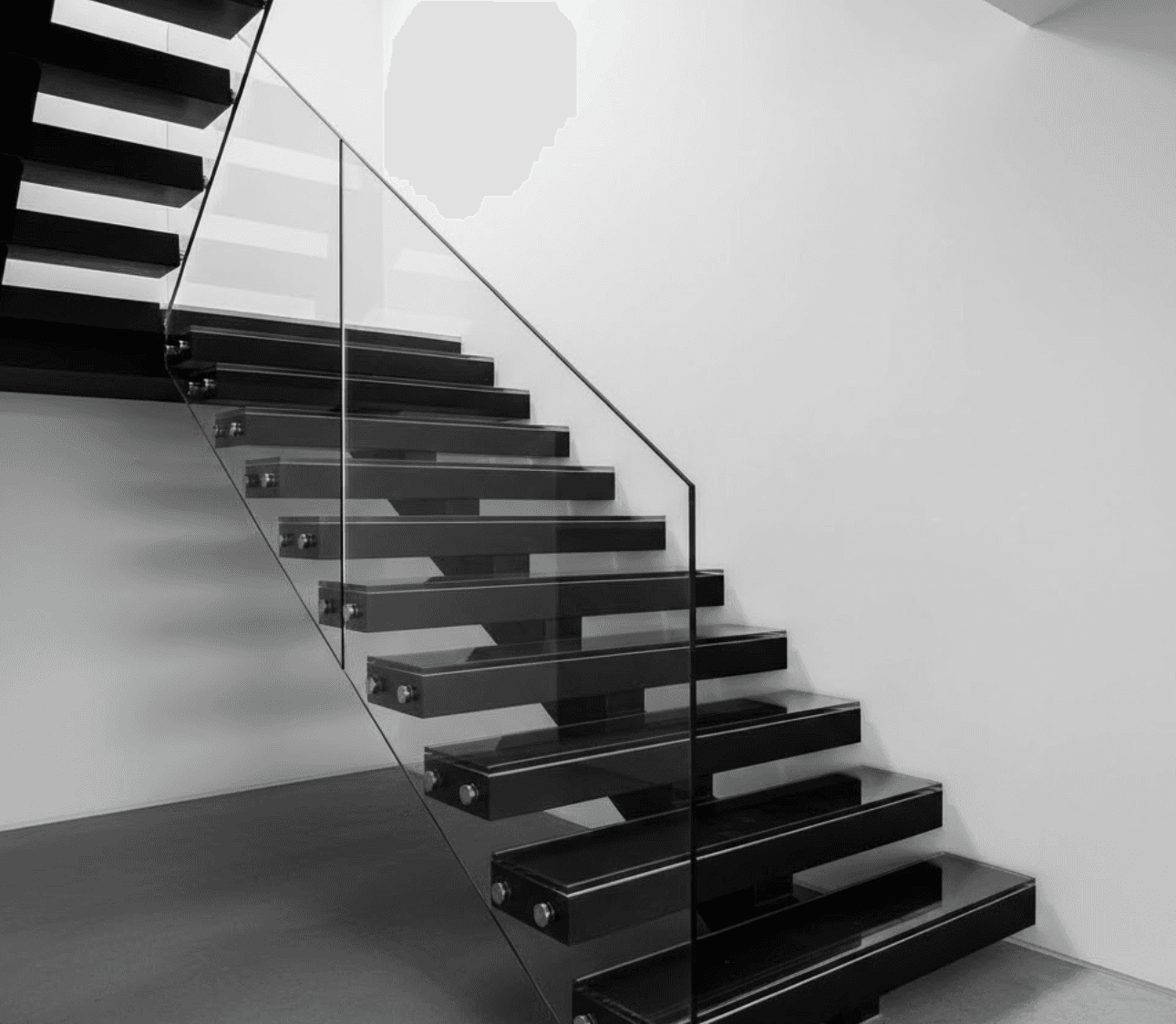 : Staircase featuring clear glass treads with matte black solid risers creating striking contrast. Thick glass treads with polished edges. 