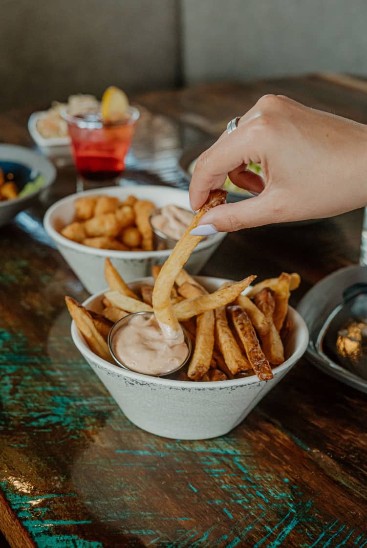 French fries bowl with dip on a restaurant table