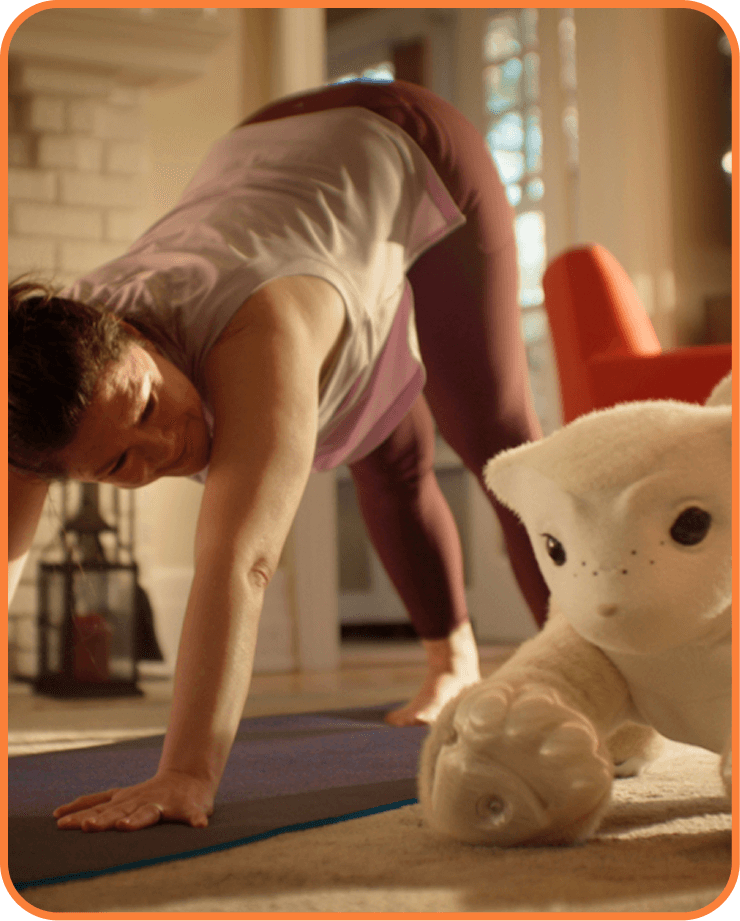 Woman doing downward dog yoga pose beside a familiar