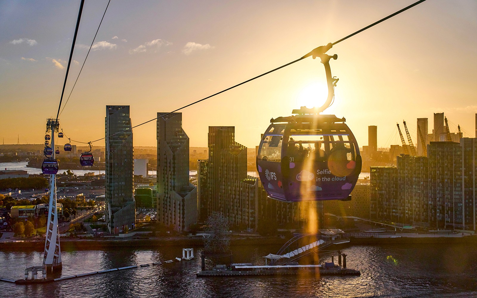 IFS Cloud Cable Car over London skyline at sundown.