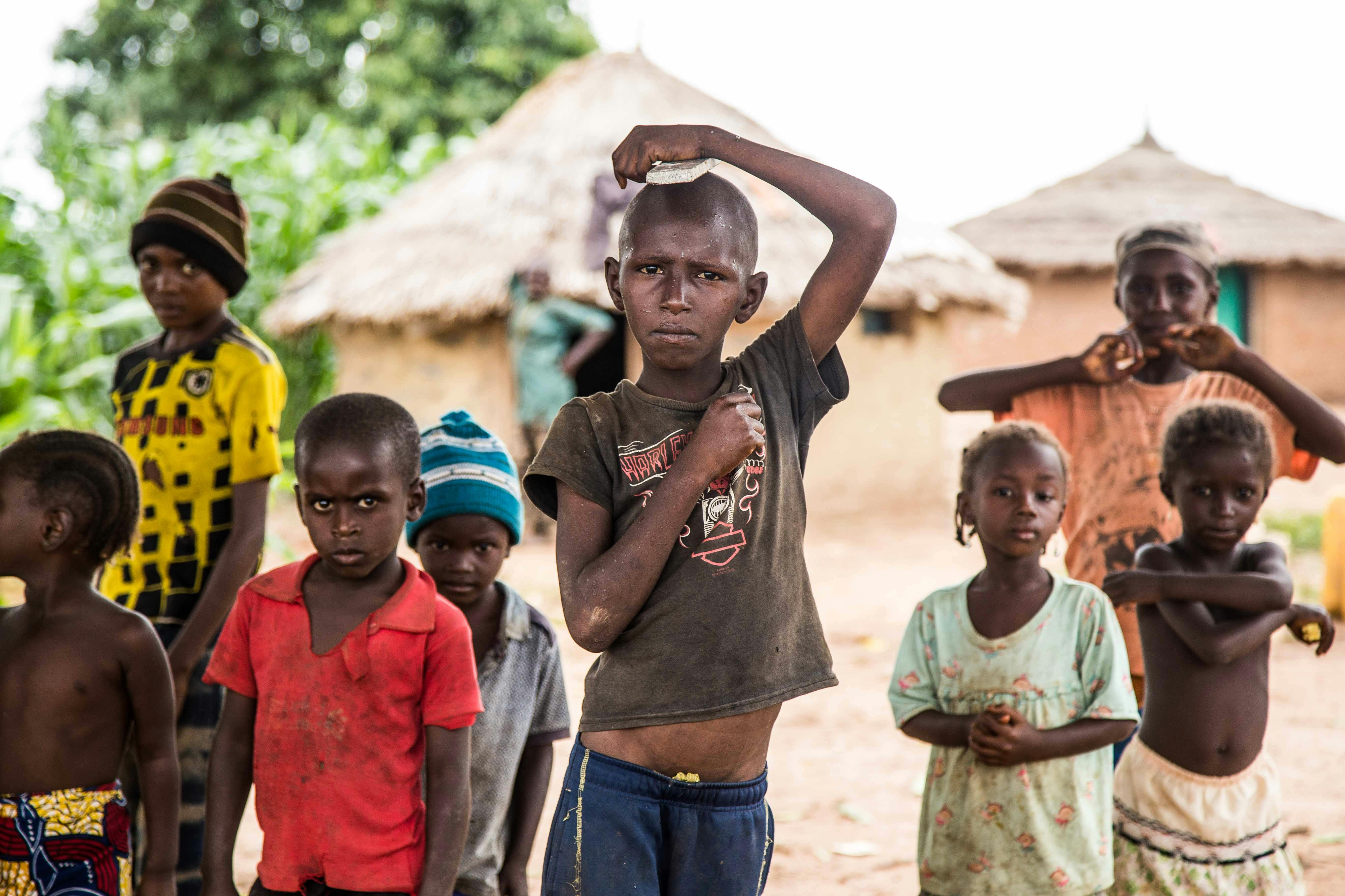 Silhouette of a researcher examining a slide under a microscope with a blue background.