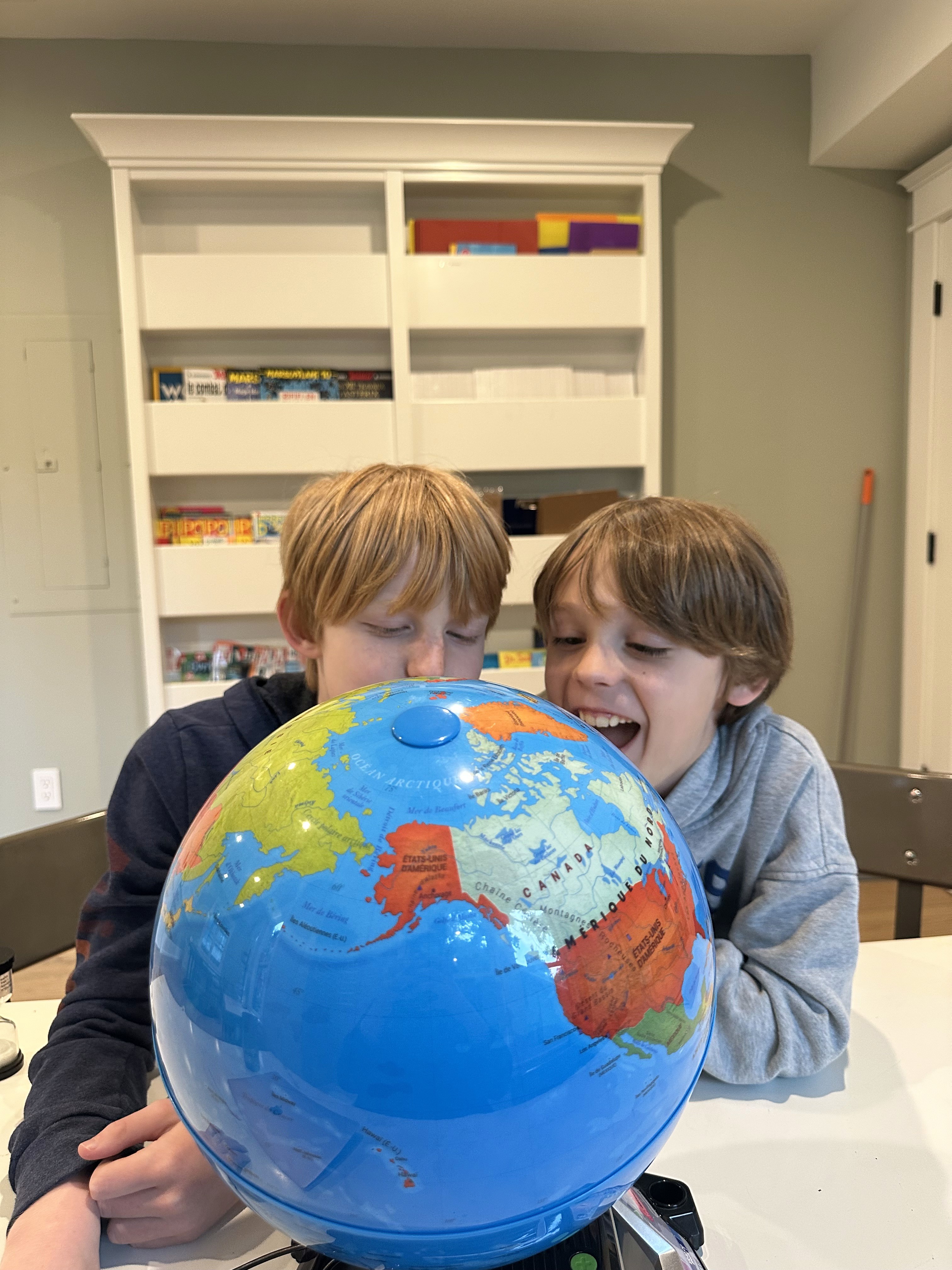 a young boy is drawing on a piece of paper