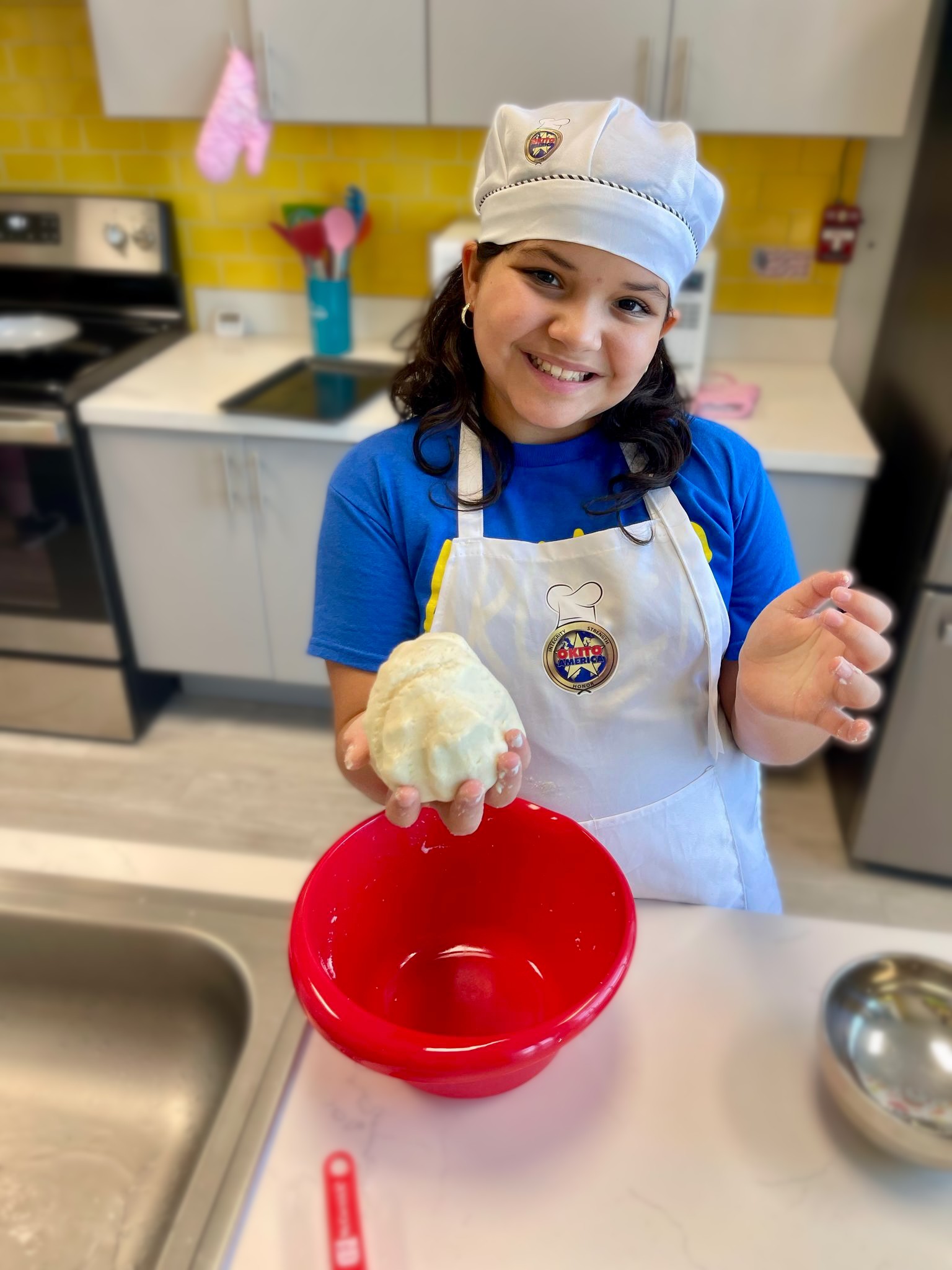 Childr participating in cooking class smiling at camera.