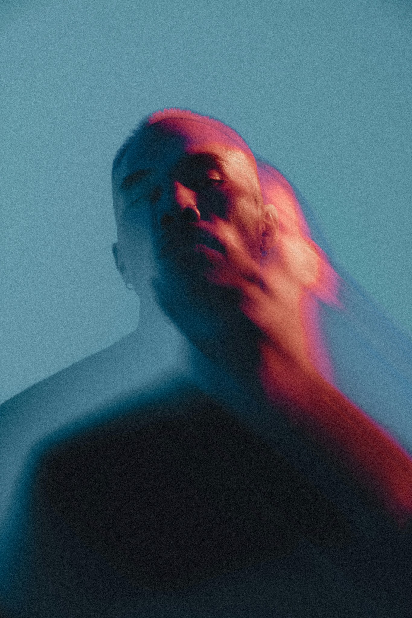 Man with blurred face in red and blue light