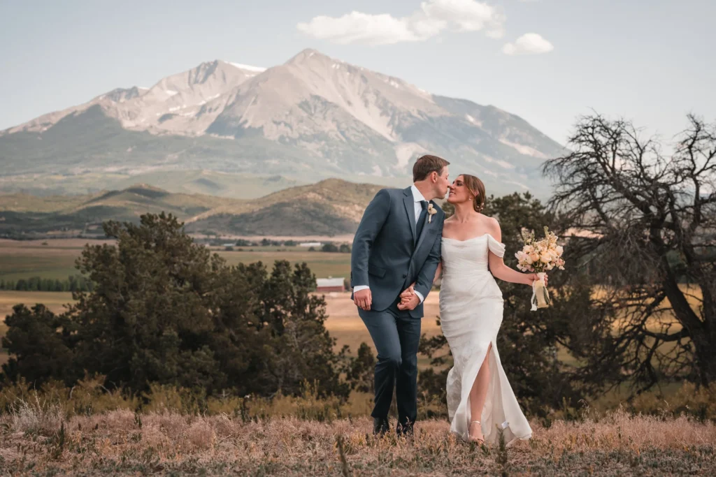 Newlyweds kissing at a mountain overlook