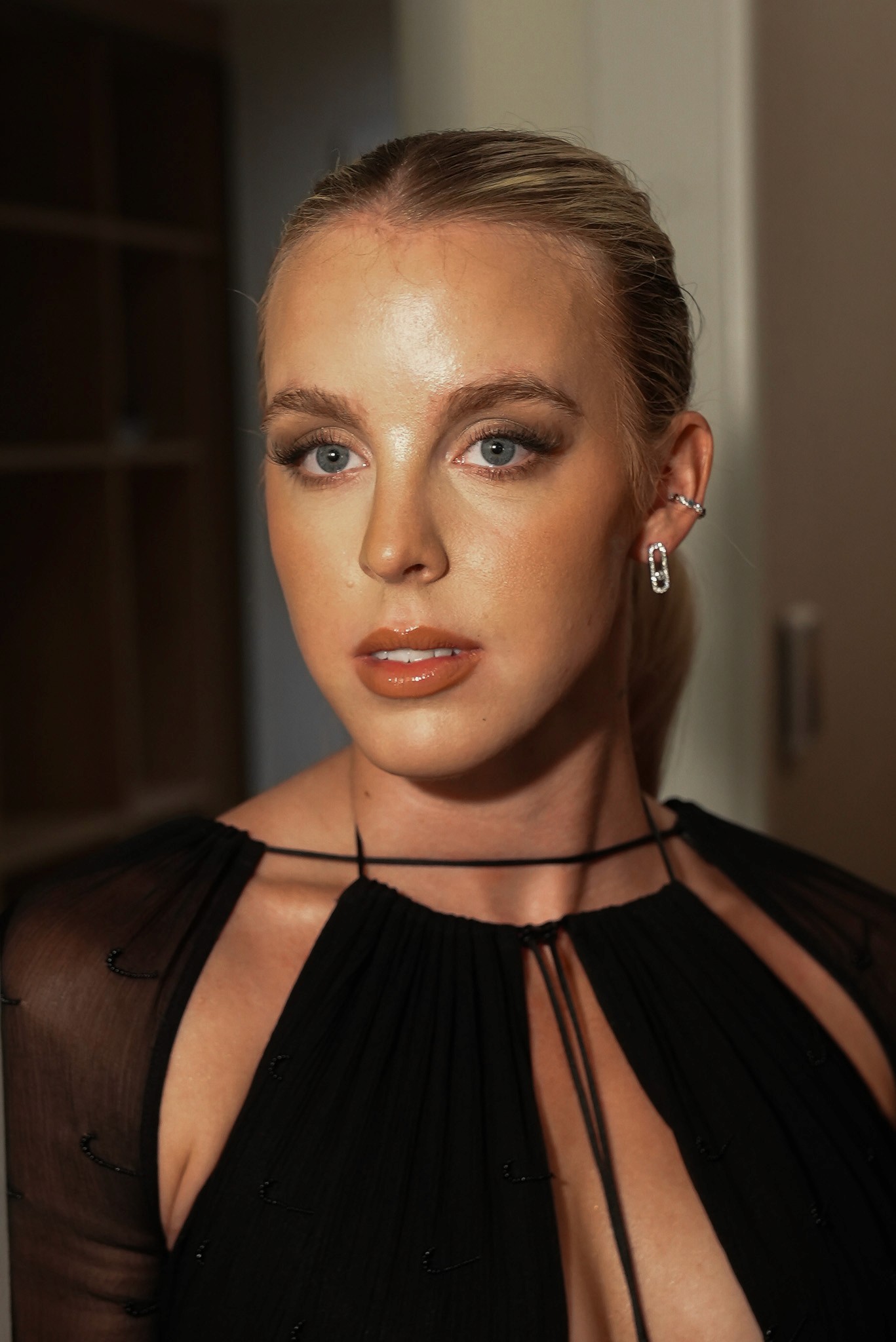 Three models standing in a wheat field, wearing beige suits.
