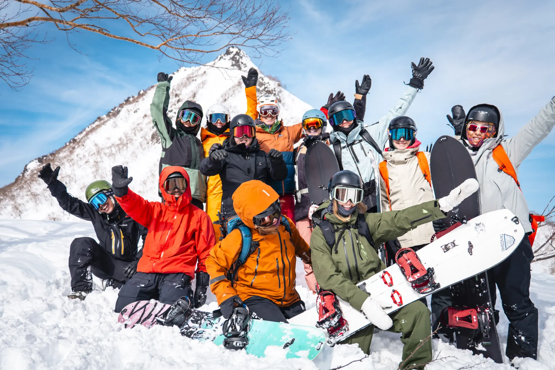 Women’s powder tour group celebrating on a summit in Myoko, Japan