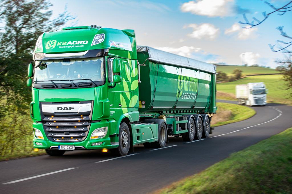 a white semi truck driving down a rural road
