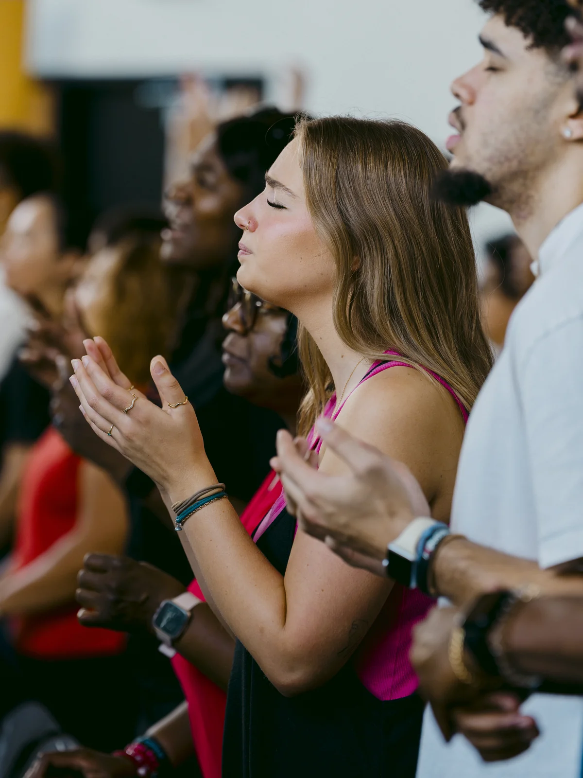 Woman worshipping with eyes closed and hands open during Sunday worship at Elan Church