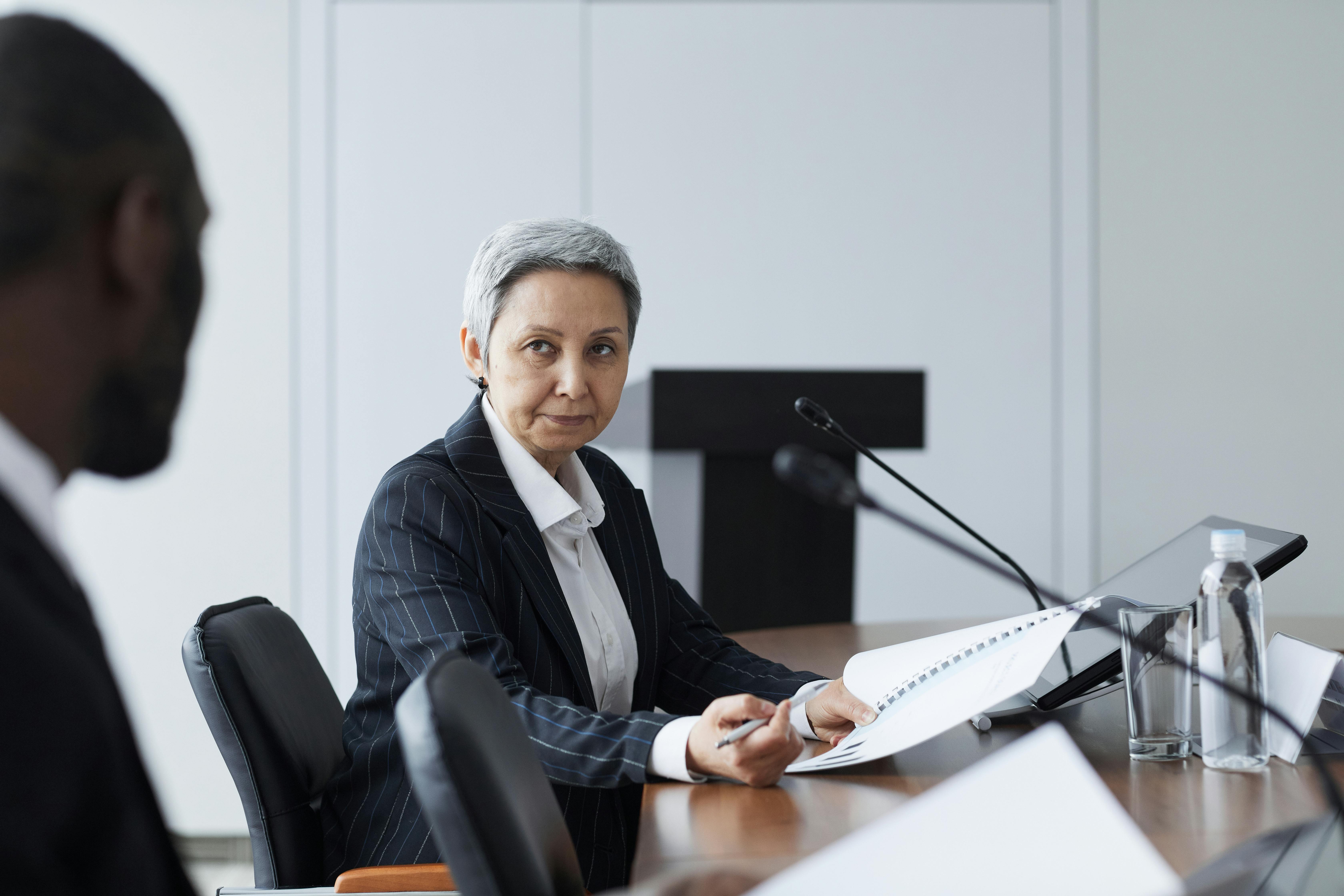 woman sitting around table holding tablet