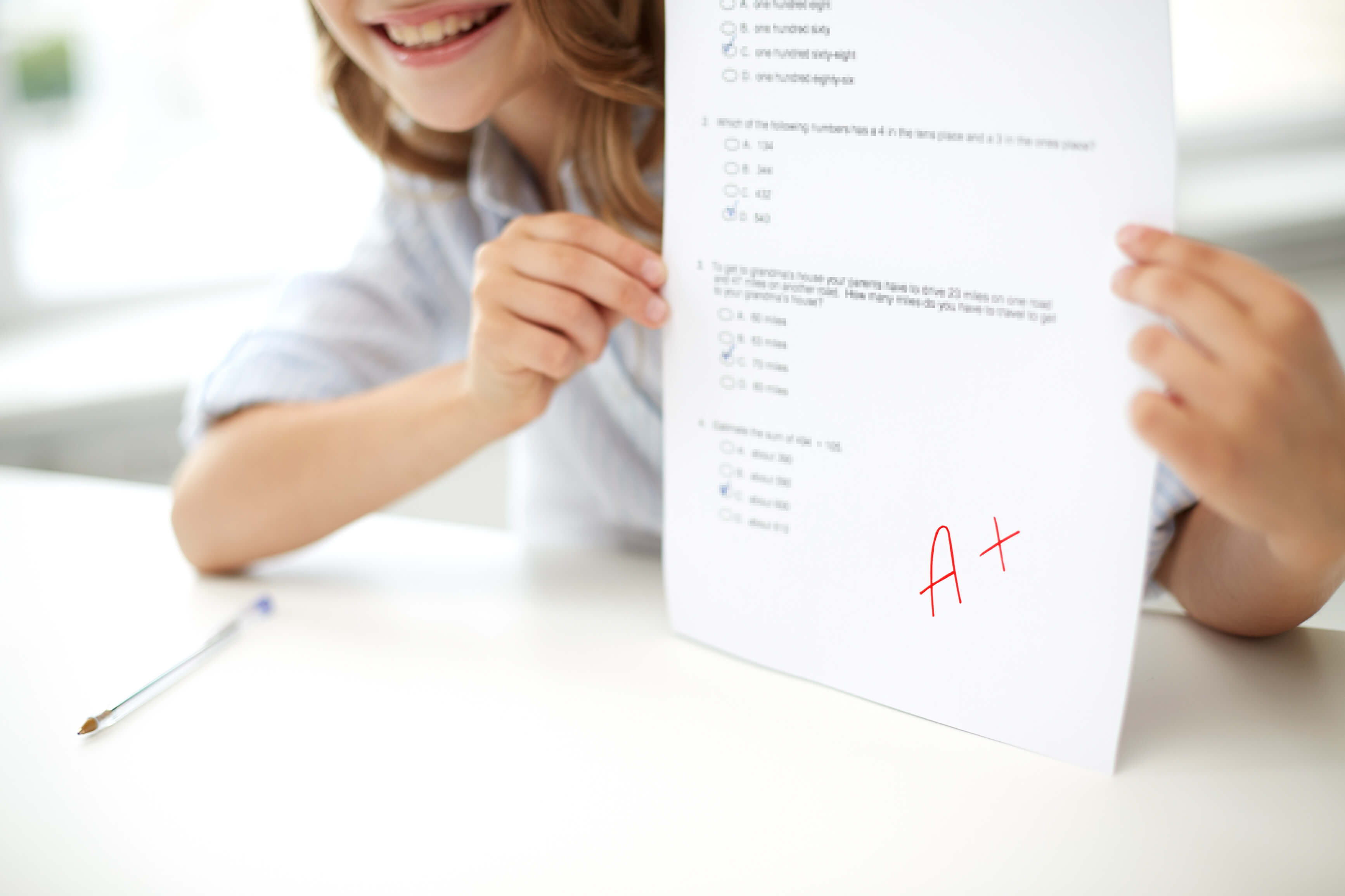 A teacher stands near a whiteboard in a classroom, explaining a lesson to the students.