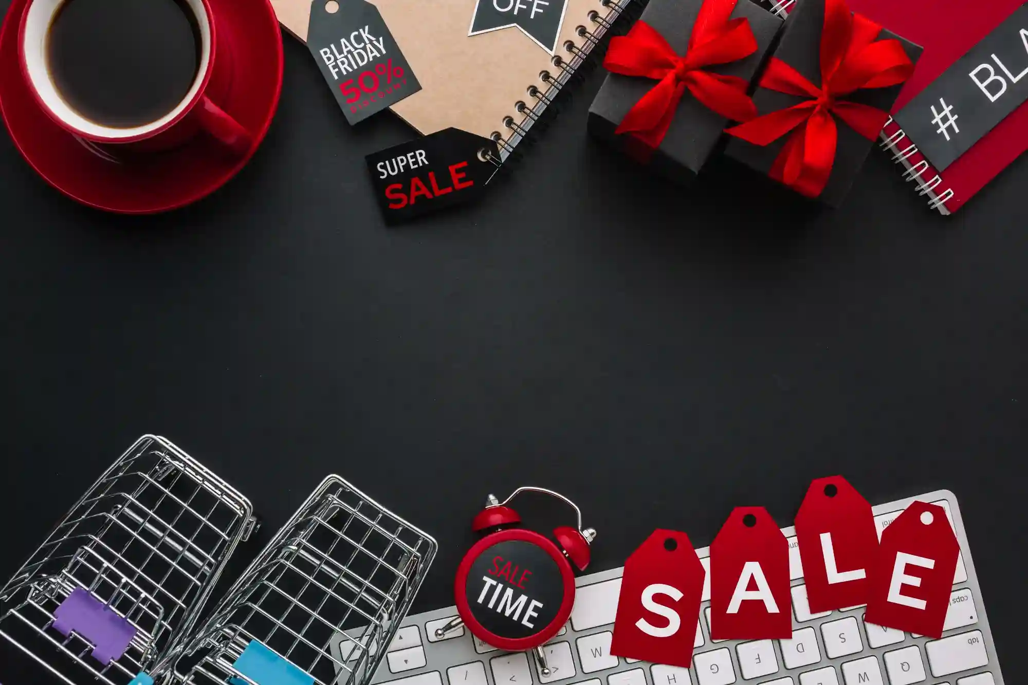 A flat lay of shopping carts, gifts, a coffee cup, and "SALE" tags on a keyboard, suggesting online shopping deals.