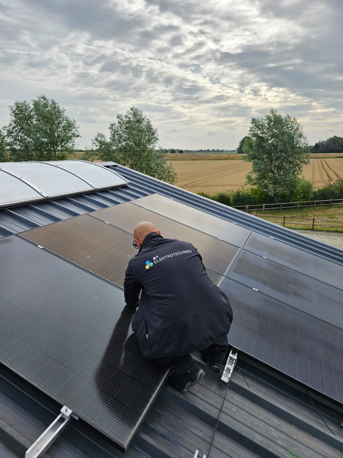 A+ Elektrotechniek medewerker monteert een zonnepaneel