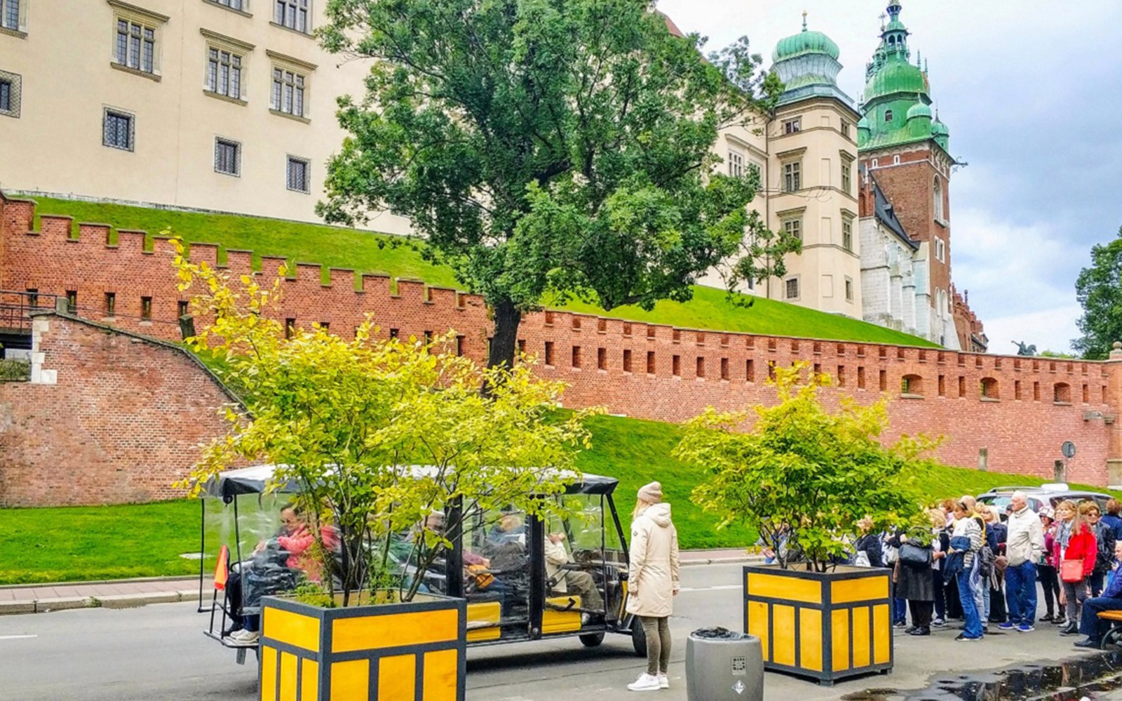 Golfkarrit rond Wawel-kasteel in Krakau, met toeristen en historische architectuur.