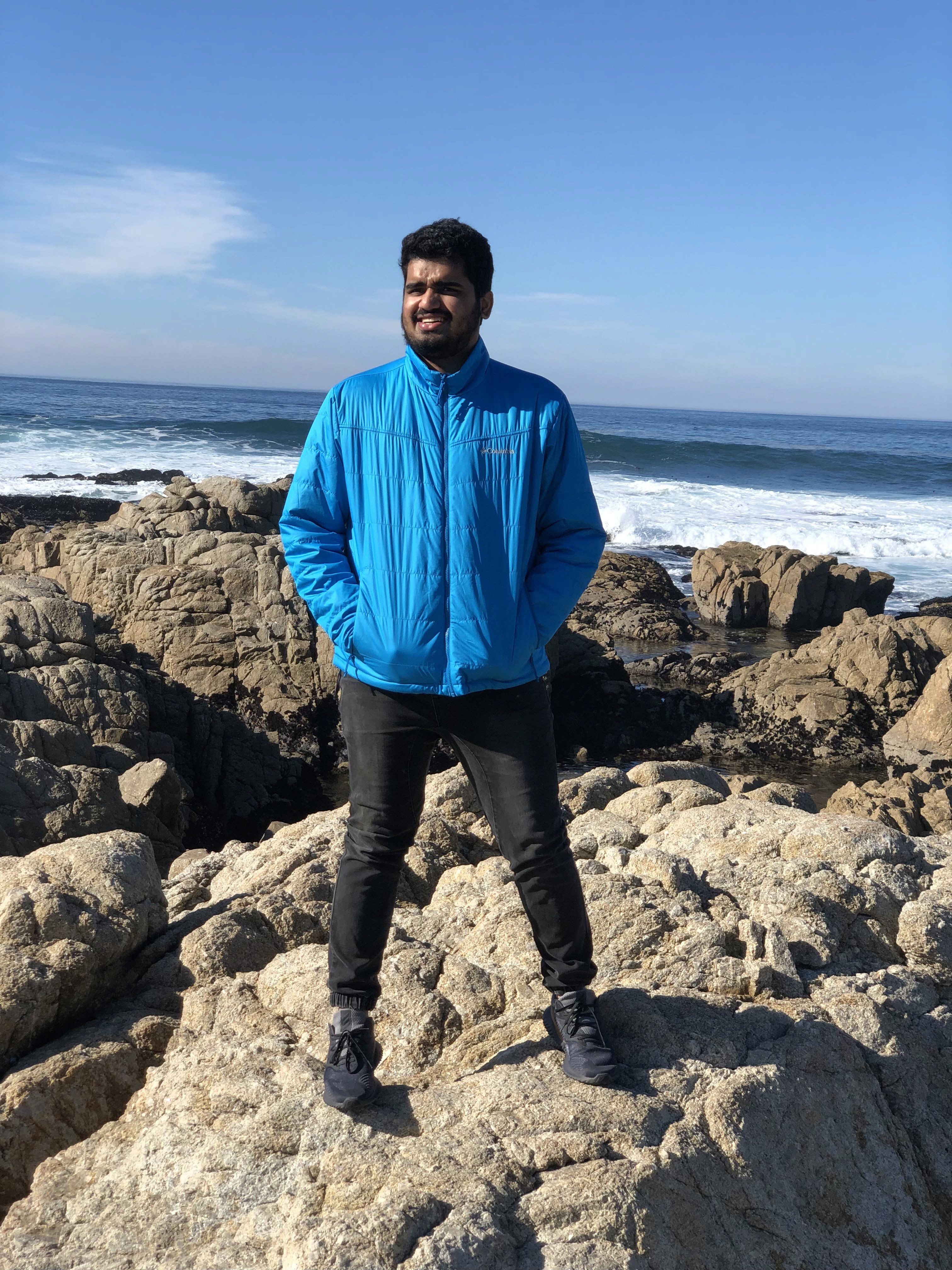 Two men discuss a project while standing at a laptop in an office.