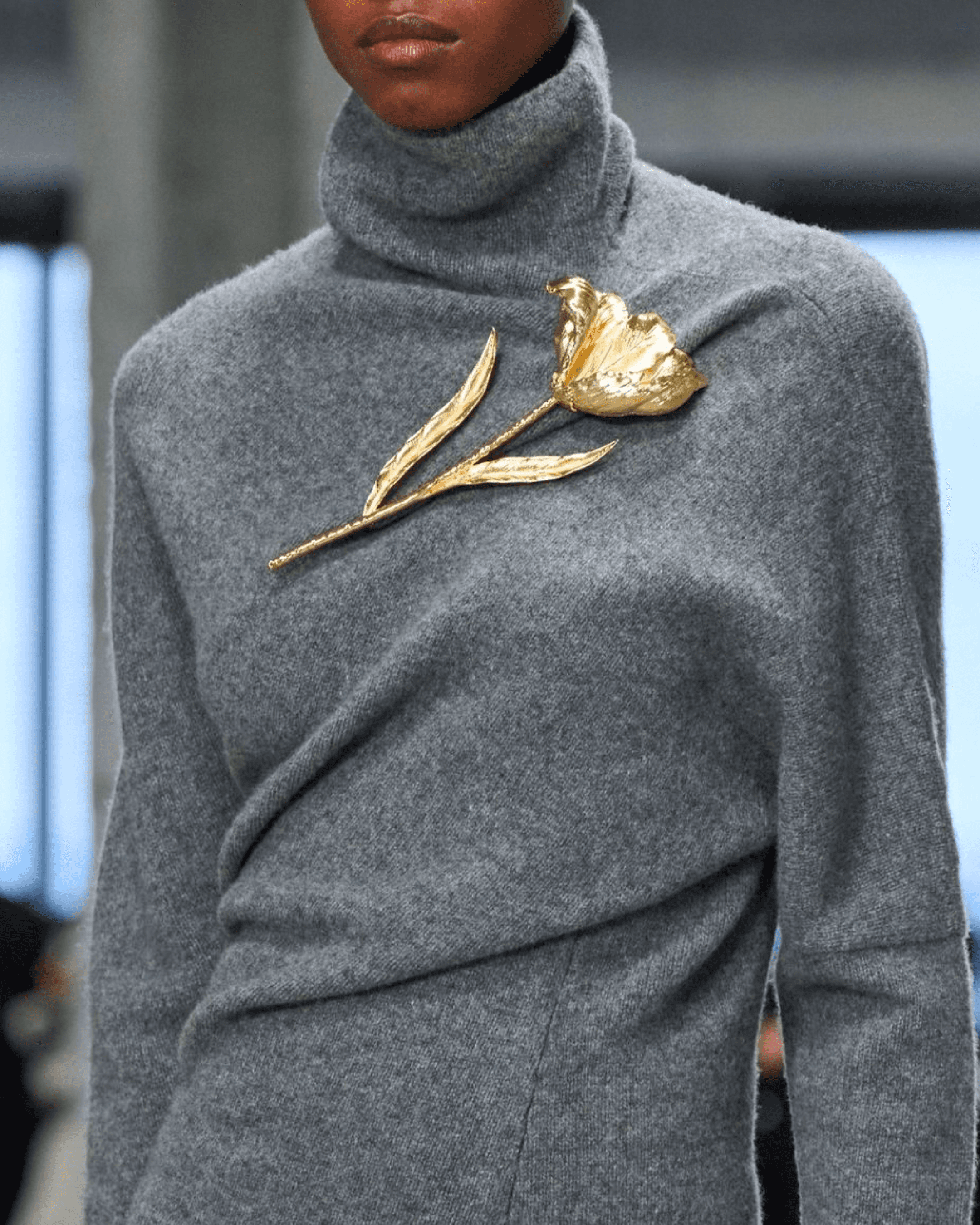 View of the French countryside through a stone villa’s open living room, with sofas and trees framing the scene