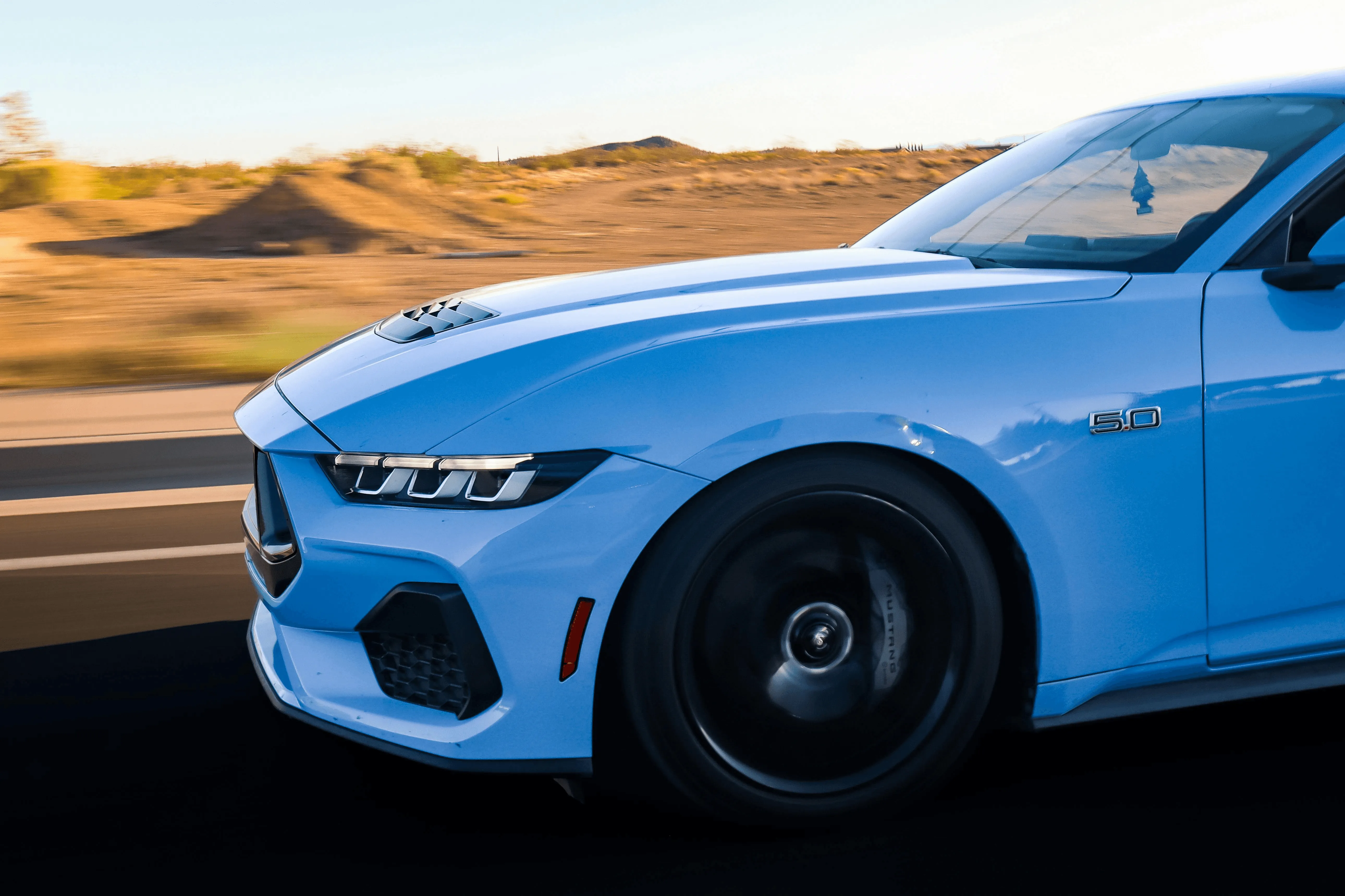 a blue sports car going for a leisurely drive