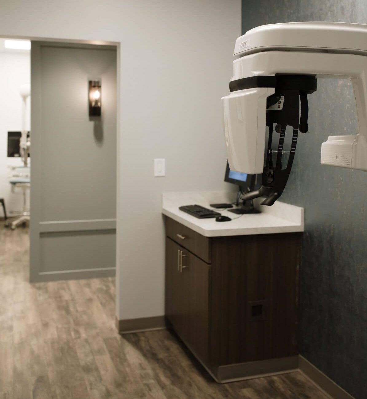 A modern dental or medical office interior featuring equipment, cabinets, and a neutral color scheme.
