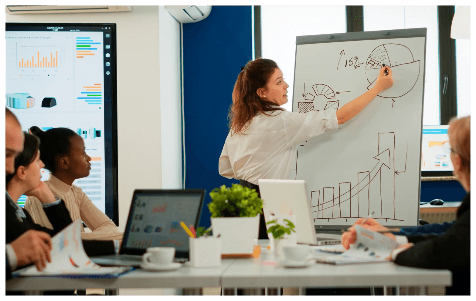 Woman presents data to office team - How To Follow Up With A Sales Lead