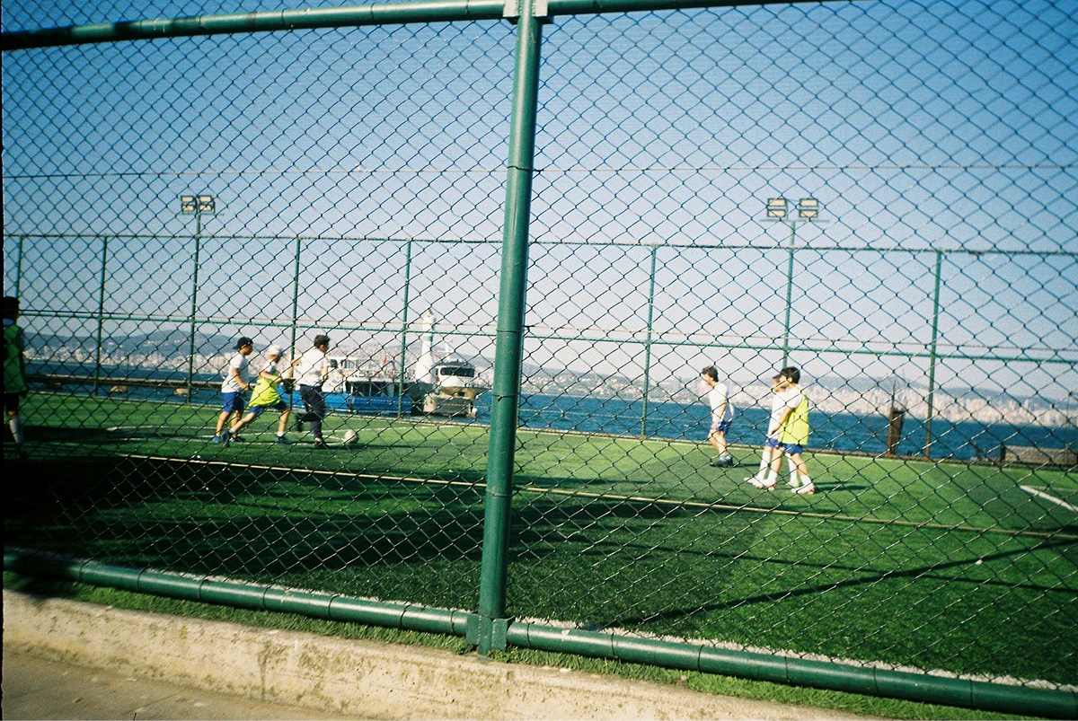 Players on an enclosed outdoor artificial-turf soccer field