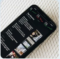 person wearing suit reading business newspaper