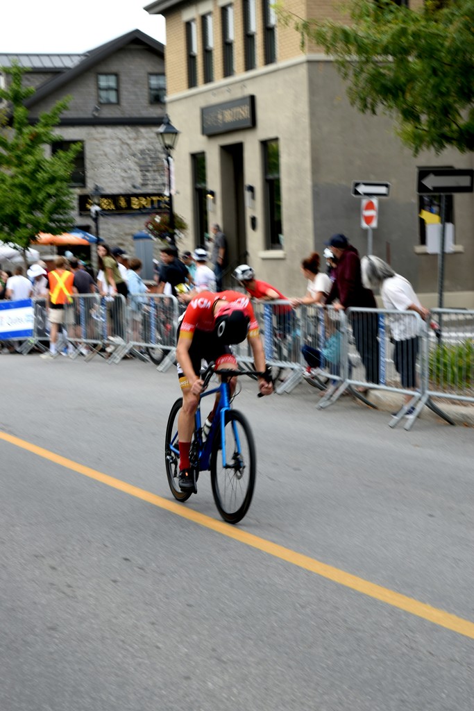 a man riding a bike down a street next to a crowd of people