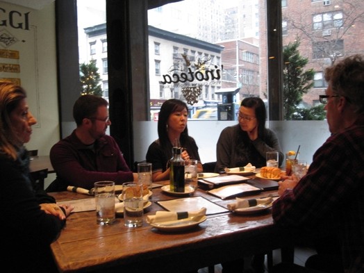 A photo of a group of people having dinner in a restaurant.