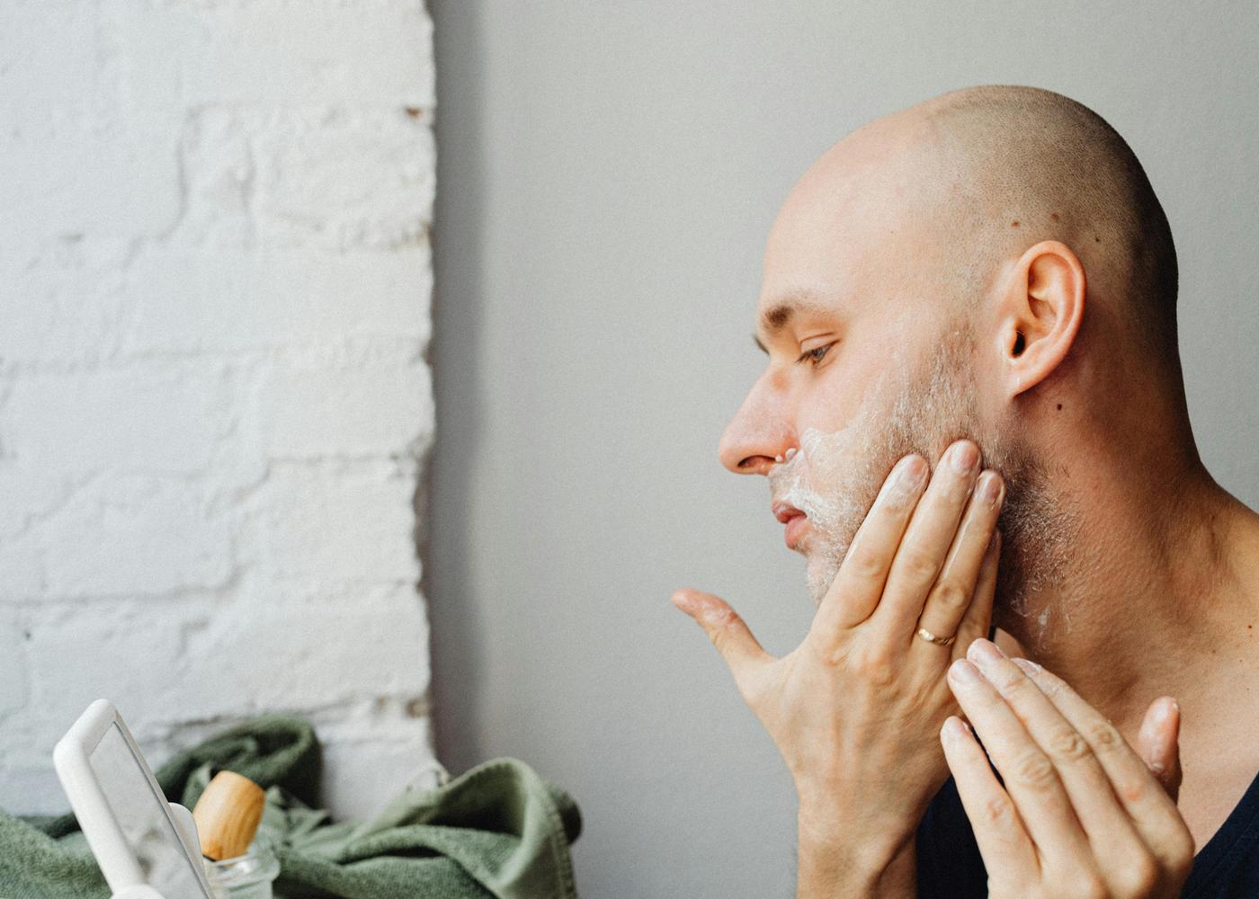 Minoxidil for beard growth - man applying serum to his beard