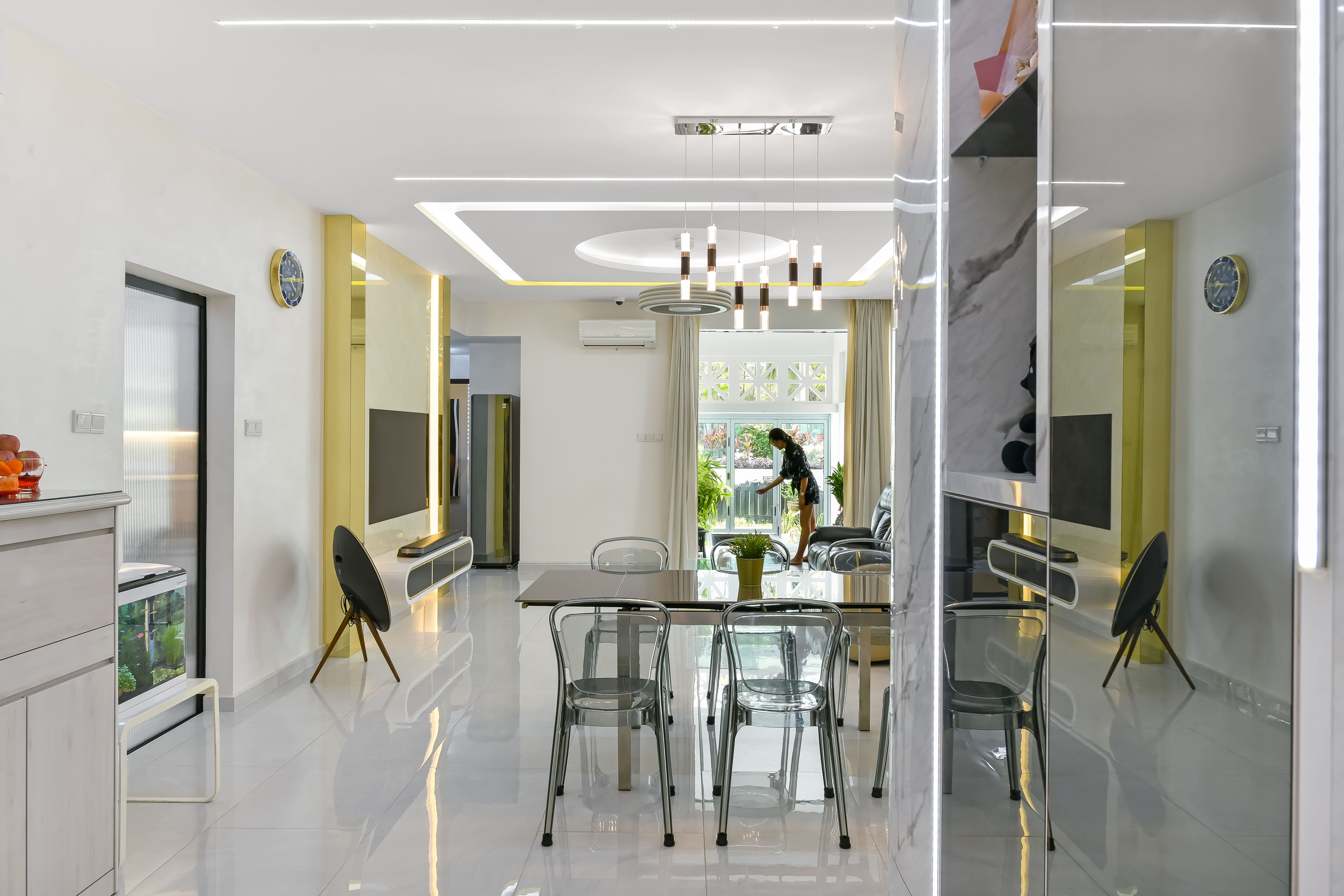 Bright and airy view from dining to living area, with ceiling LED strip lights and natural light flowing in through full-height windows.