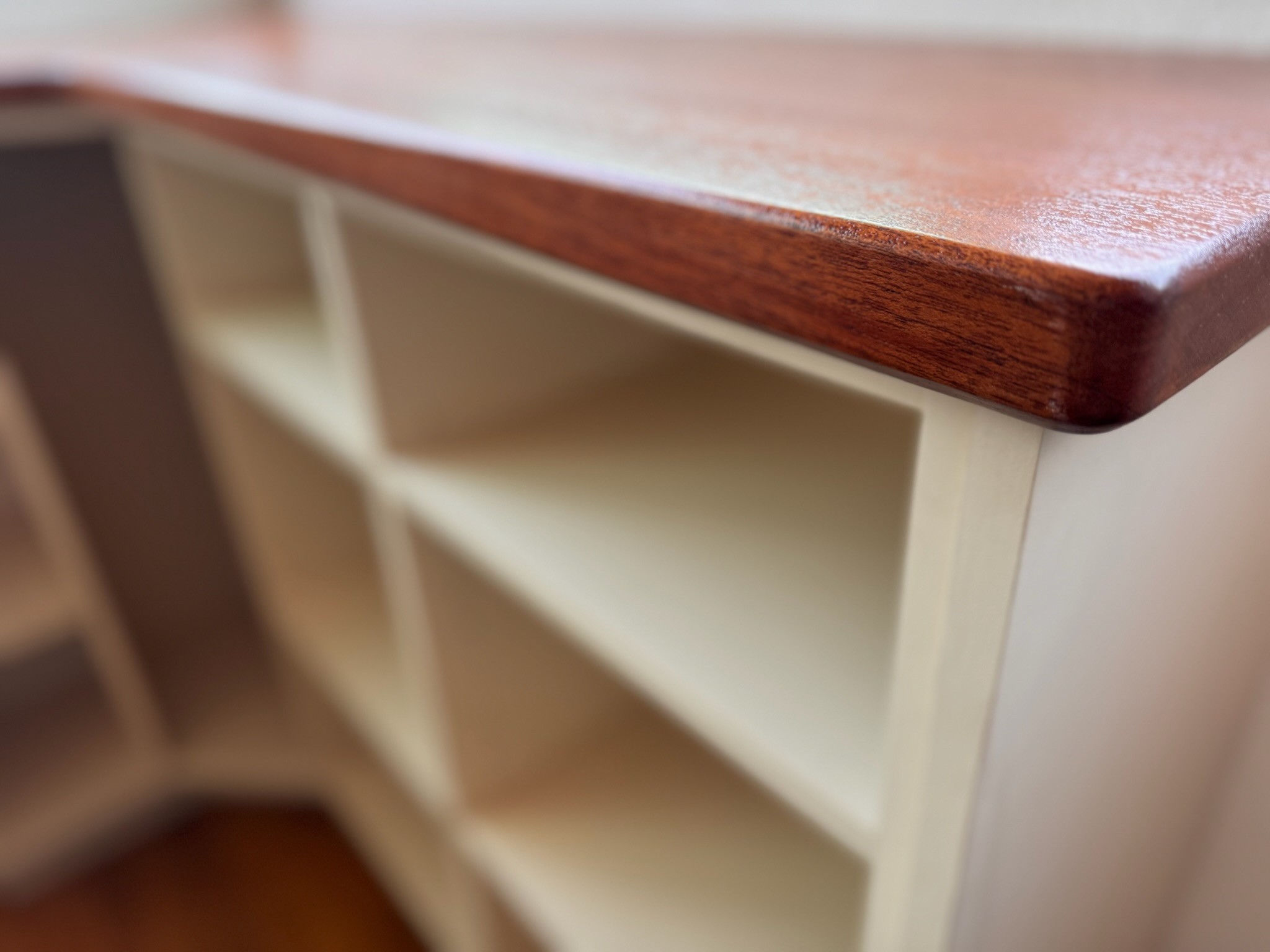 Rounded wood countertop edge above white cabinetry