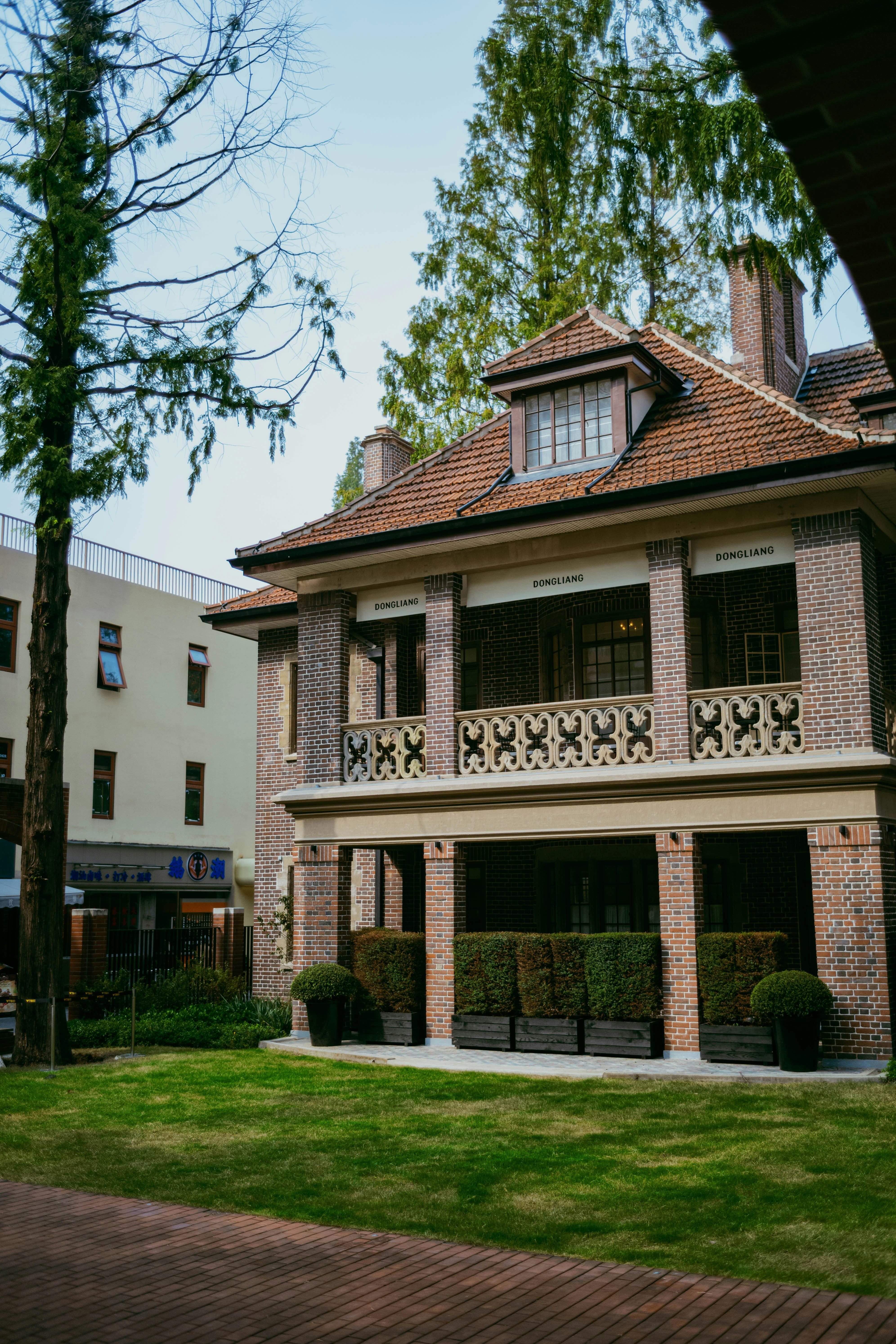 Brick building with balcony and manicured bushes