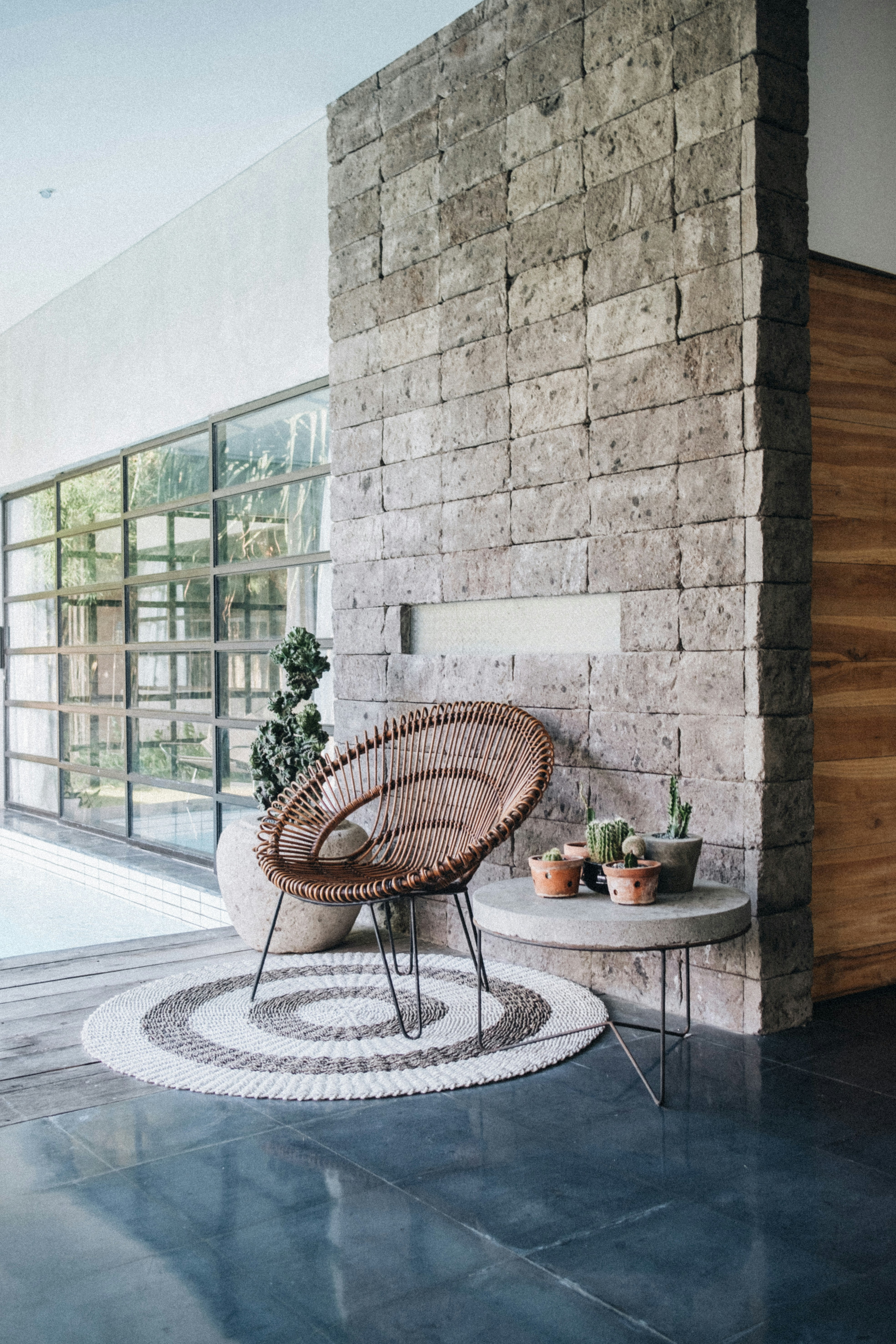 Outdoor living space with a rattan chair and a brick wall.