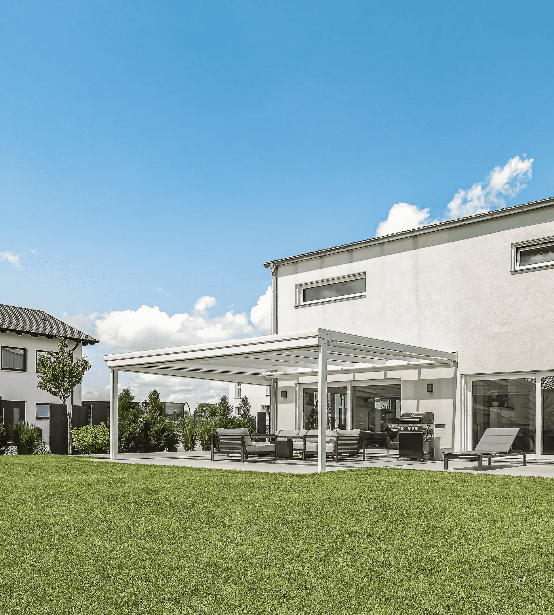Darstellung einer großen weißen Terrassenüberdachung an modernem Neubau