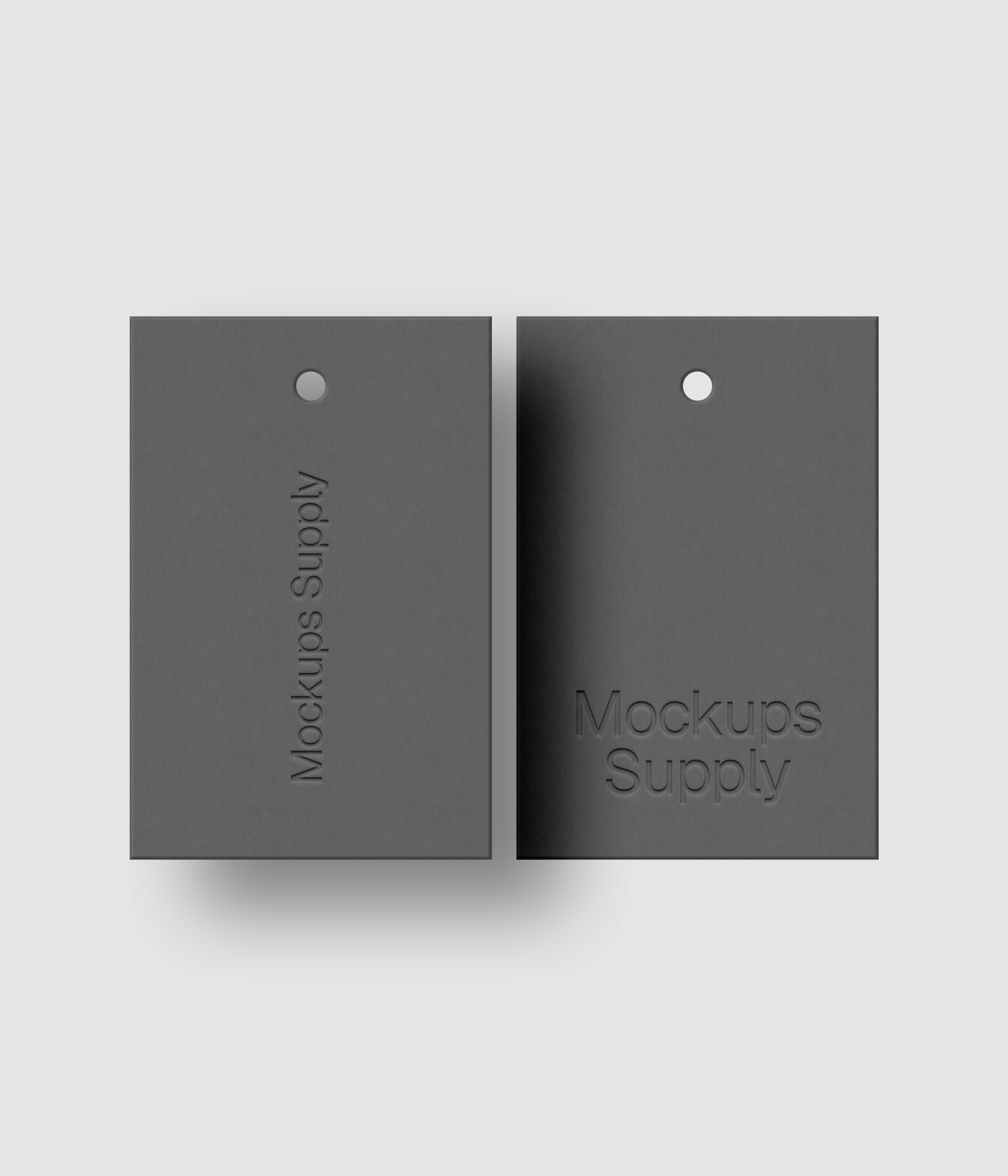 Two gray 2x3 hang tags mockup on white background with debossed logo effect and natural shadow depth for Photoshop download psd