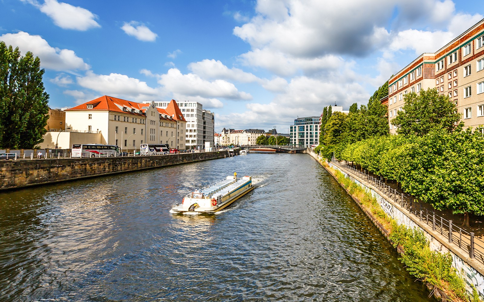 Łódź na rzece Sprewie mijająca Katedrę Berlińską i Wieżę Telewizyjną w ramach wycieczki typu hop-on hop-off.
