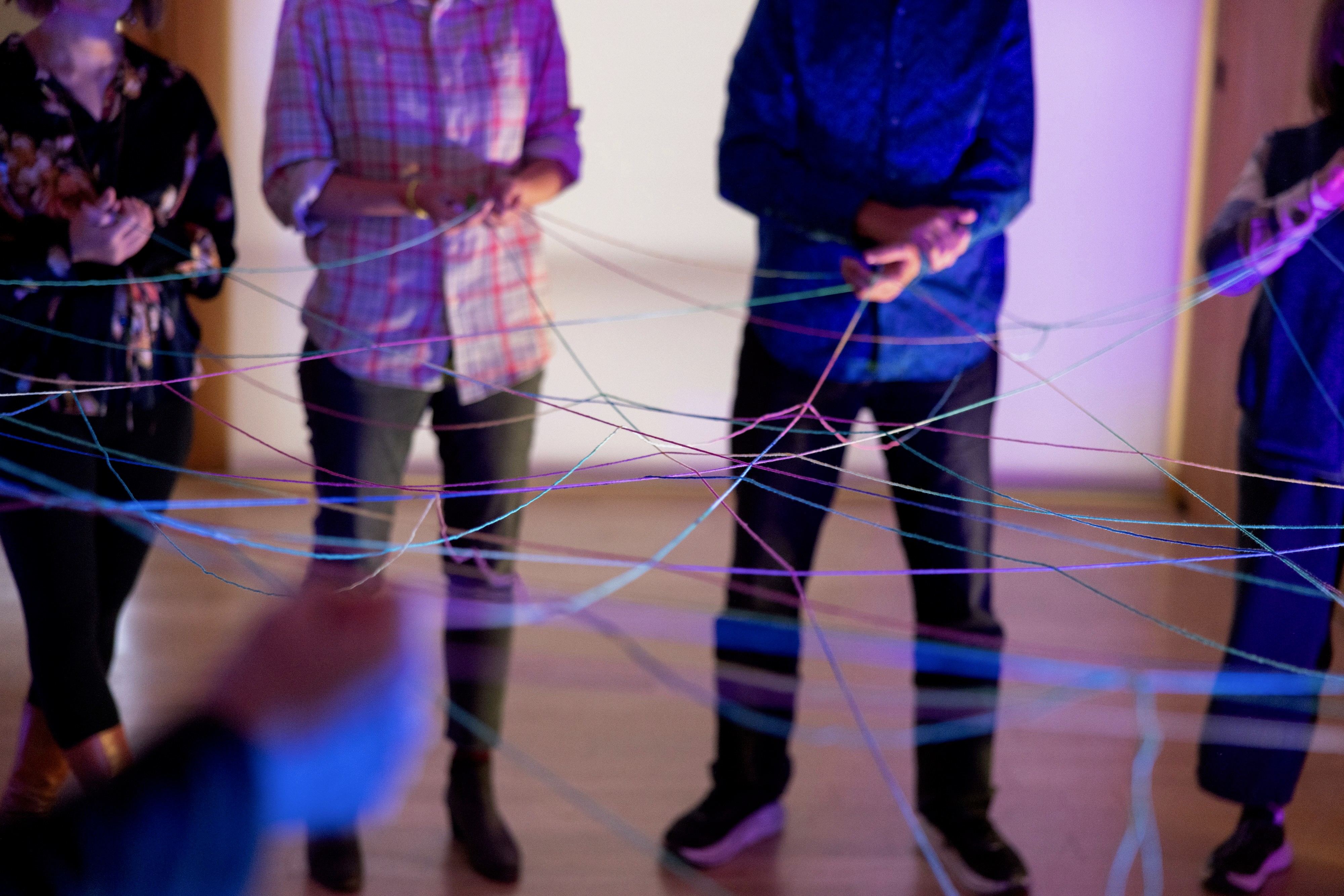 A restaurant interior featuring marble countertops, brown leather chairs, wood-paneled walls, and round pendant lights hanging above a bar set with wine glasses.