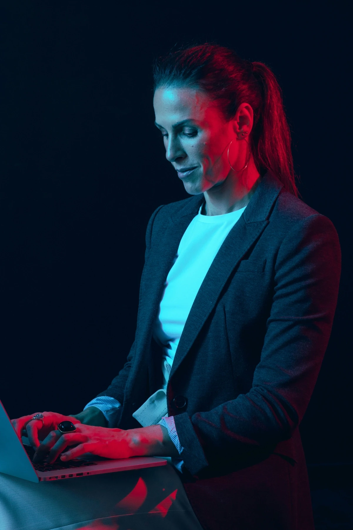Sarah M. Kling, CEO von ELOQ, arbeitet konzentriert an einem Laptop in kontrastreicher Schwarz-Weiß-Ästhetik.