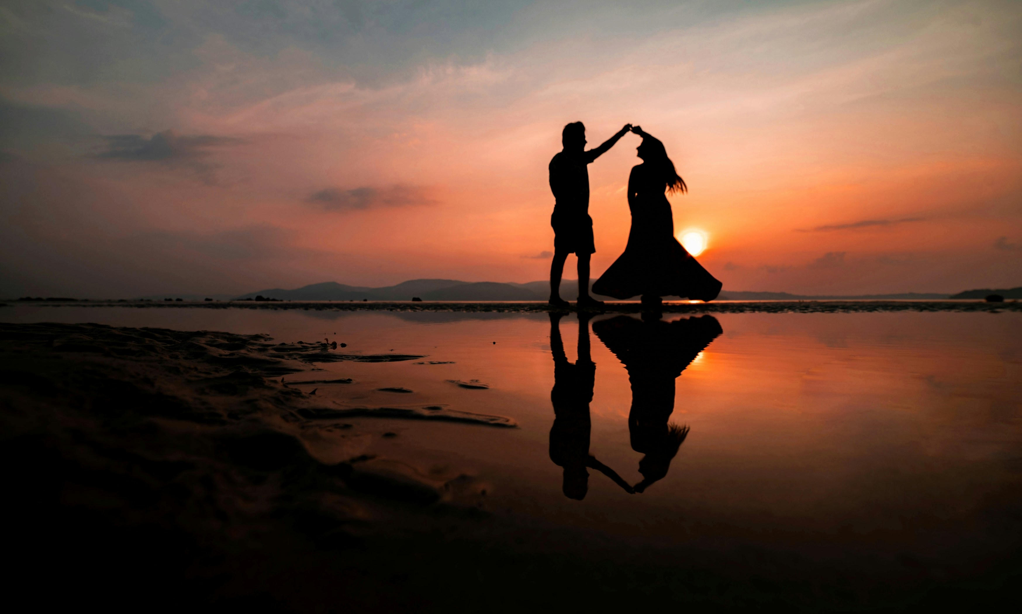 couple dancing on the beach at sunset