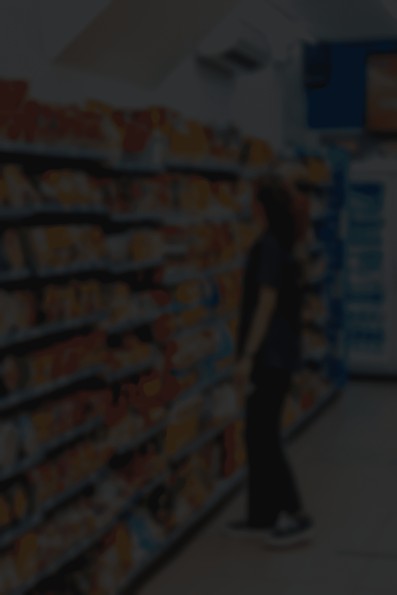 a woman standing in front of a display of food