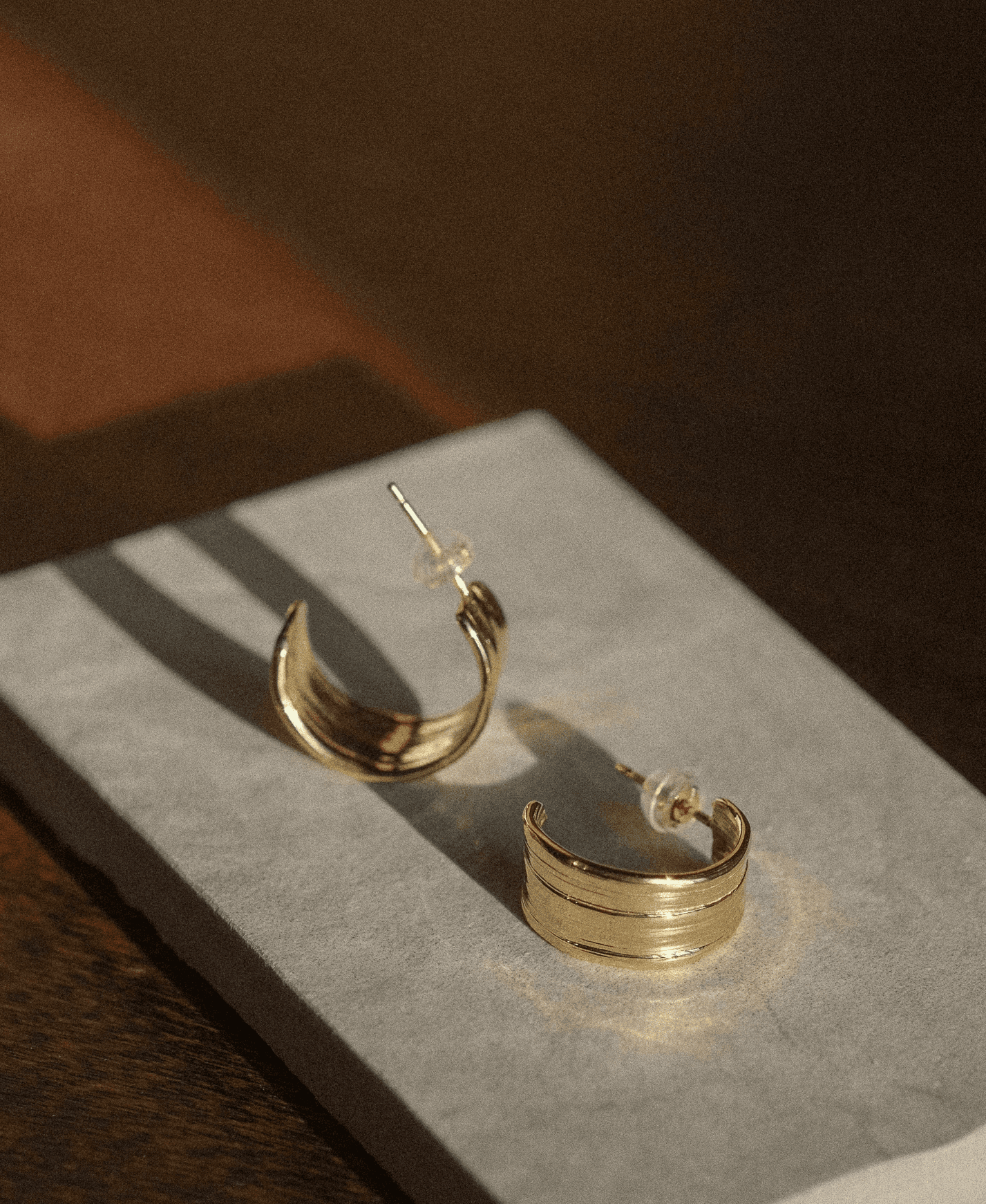Unique large gold hoops rested on marble