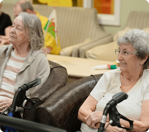 Three older adults are looking at a paper.