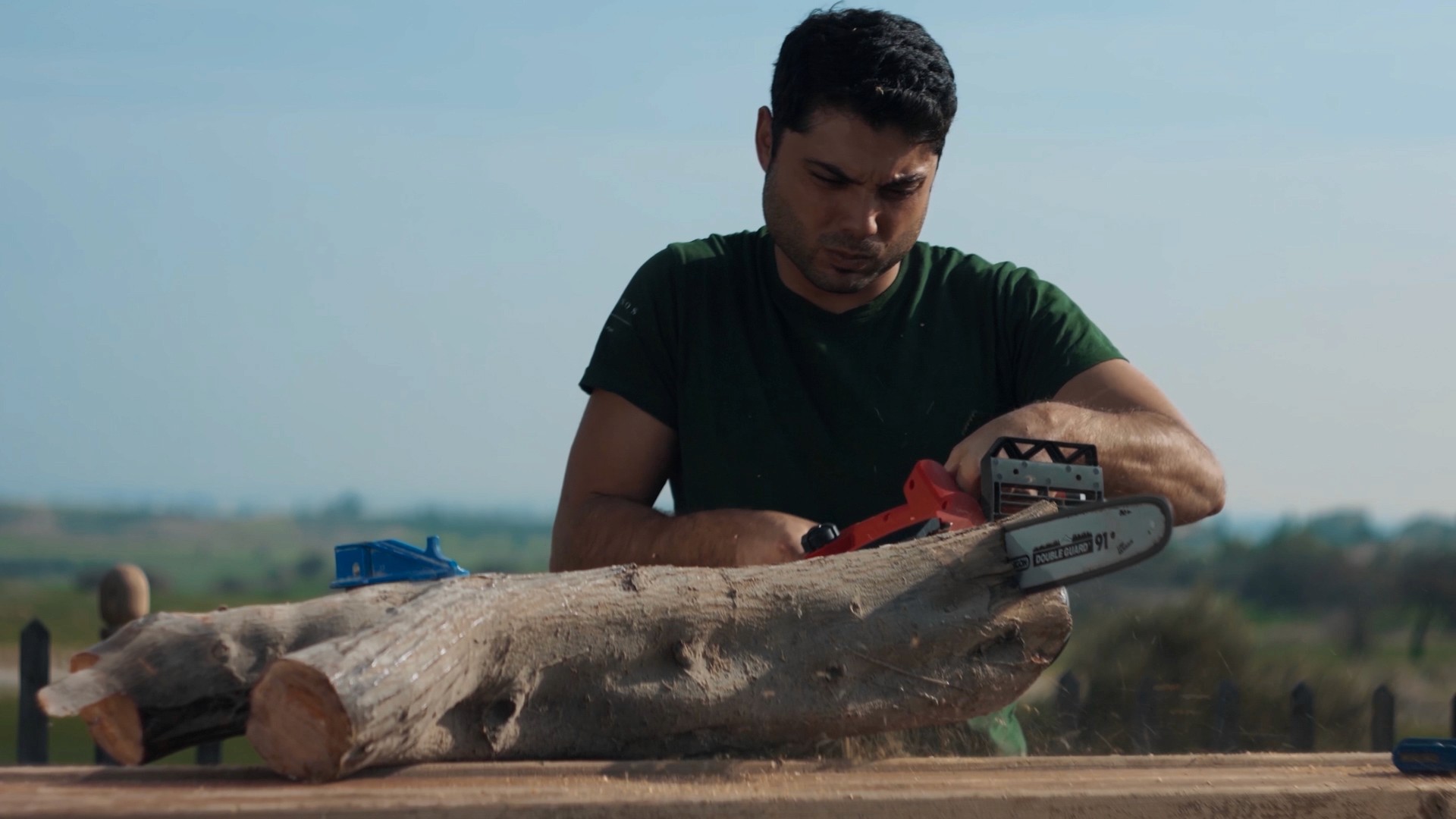 The pipe maker is cutting a big piece of olive wood