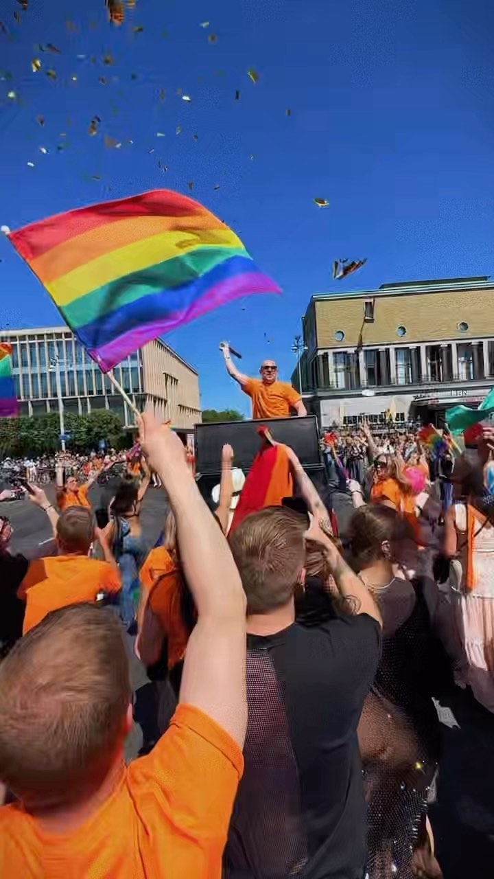 Pride regnsbågsflagga flaggas i Pridetåg en solig dag.