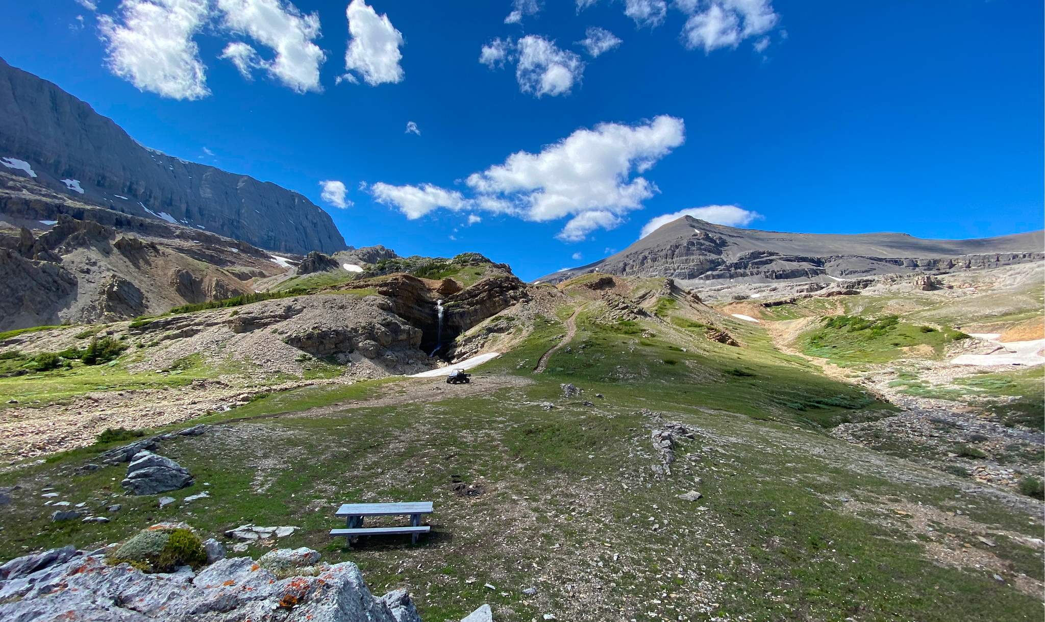 High-alpine trail terminus at Cardinal River Headwaters with picnic area, waterfall, and Rocky Mountain backdrop in Whitehorse Wildland Provincial Park