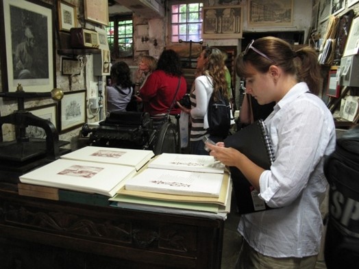 A photo of a girl looking at some fresh prints in an art workshop.