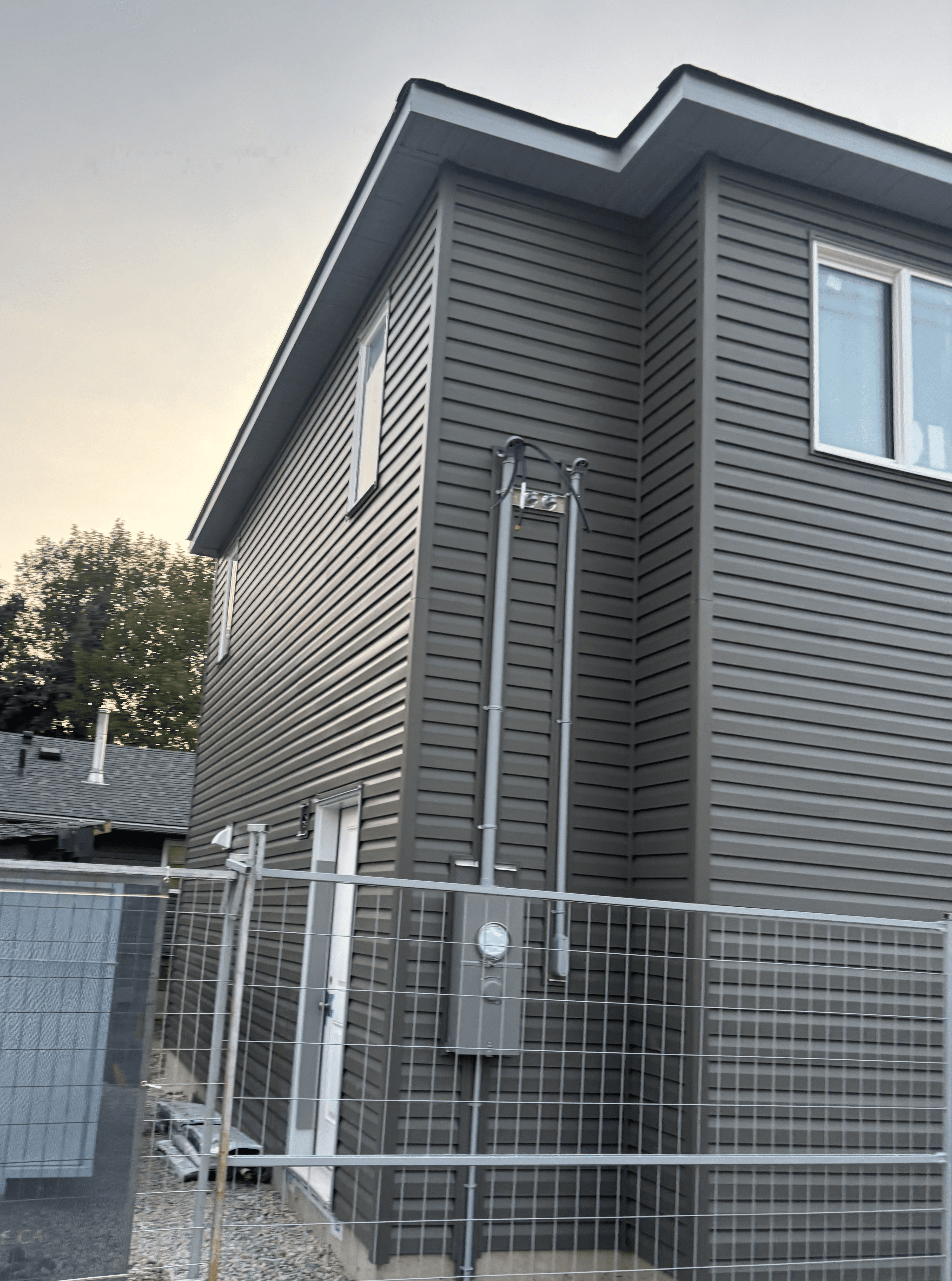 Two-storey garage suite with grey vinyl siding and white soffit/fascia