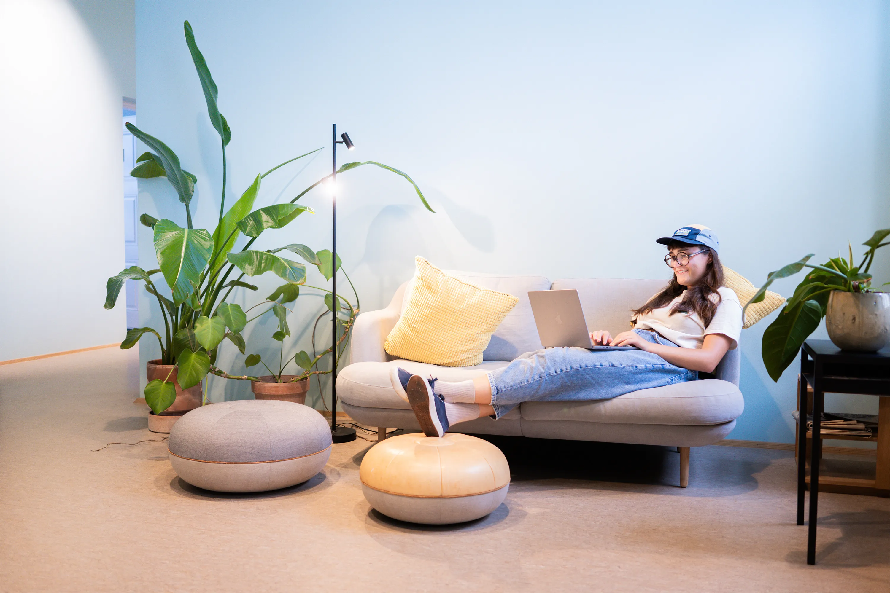 Francesca working with her laptop on a couch smiling