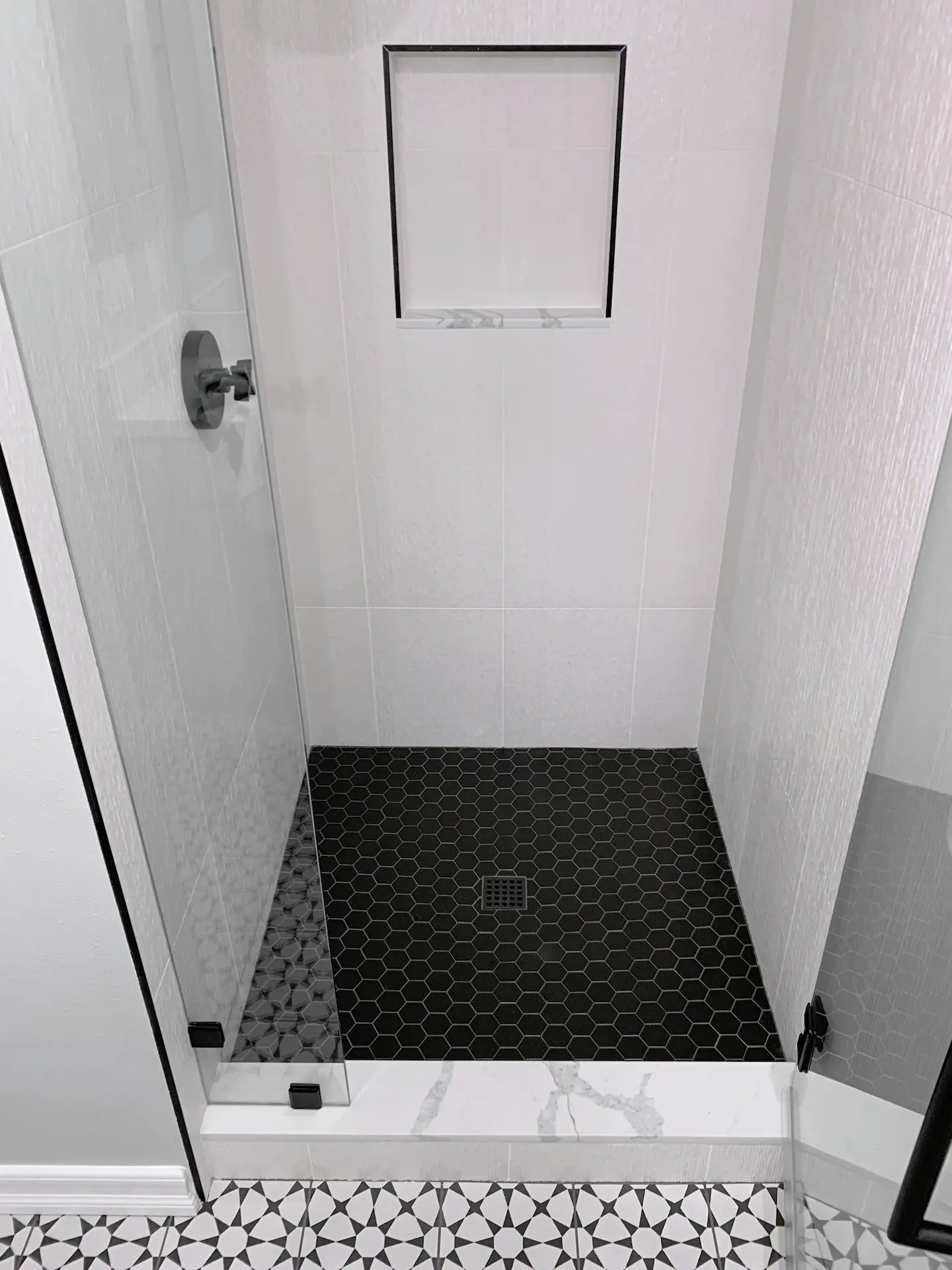 Overhead view of the guest bath shower enclosure, showcasing the elegant textured wall tile and spacious design. Photo by Todd Huge.